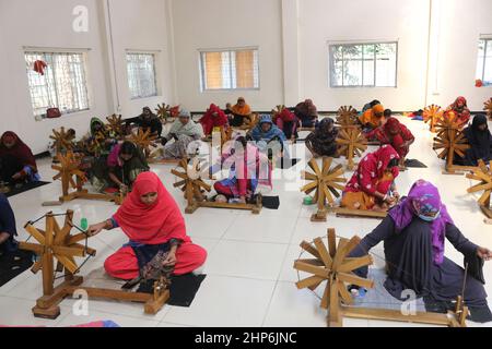 In Rupganj am Stadtrand von Dhaka machen Arbeiter mit traditionellem tat Sari Stockfoto