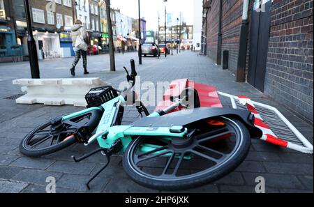 (220219) -- LONDON, 19. Februar 2022 (Xinhua) -- das Foto vom 18. Februar 2022 zeigt eine Frau, die während der starken Winde des Sturms Eunice in London, Großbritannien, an einem gefallenen Fahrrad vorbeiläuft. Eunice gilt als einer der schlimmsten Stürme seit drei Jahrzehnten und hat am Freitag Rekordwind nach Großbritannien gebracht, drei Menschen getötet und im ganzen Land massive Stromausfälle, Flugausfälle und Schulschließungen verursacht. Eine Frau im Alter von 30s Jahren im Norden Londons wurde getötet, als ein Baum auf ihr Auto fiel, ein Mann im Alter von 20s Jahren starb, als sein Lastwagen in Südengland mit einem umgestürzten Baum kollidierte und ein Mann im Alter von 50s Jahren im Nordwesten Stockfoto