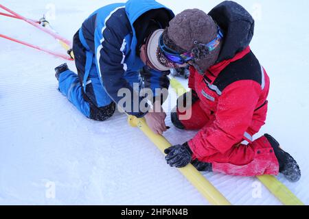 Lanzhou. 19th. Februar 2022. Das undatierte Foto zeigt, wie Ji Kaicheng (R) ein Experiment mit einem Teammitglied im Genting Snowpark in Zhangjiakou, der nordchinesischen Provinz Hebei, durchführt. ZUM THEMA „China Focus: Technisches Team unterstützt Peking 2022 Schneesportstätten“ Quelle: Xinhua/Alamy Live News Stockfoto