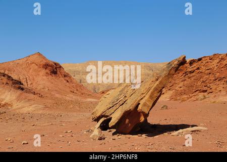 Es ist ein erosives Felsfragment, das sich gegen die steinerne Landschaft der farbenfrohen Arava-Wüste stellt. Stockfoto