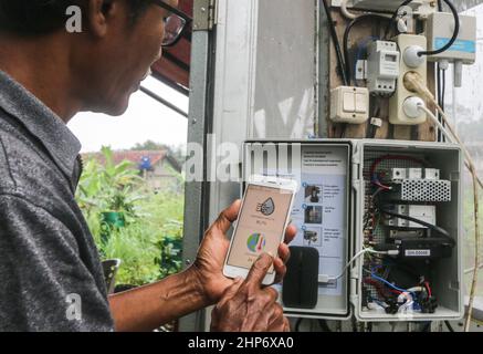 Bogor, Indonesien. 18th. Februar 2022. Ein indonesischer Landwirt wird am 18. Februar 2022 auf einem Feld in Bogor, West-Java, Indonesien, mit Hilfe moderner Agrartechnologie das Pflanzenwachstum auf seinem Gerät überwachen sehen. Es wird angenommen, dass die moderne Landwirtschaft durch den Einsatz von Technologie in der Lage ist, die Produktion, die Effizienz und die Wettbewerbsfähigkeit der landwirtschaftlichen Produkte zu steigern. (Foto von Andi M Ridwan/INA Photo Agency/Sipa USA) Quelle: SIPA USA/Alamy Live News Stockfoto