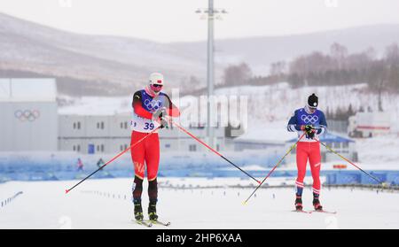 Zhangjiakou, Chinas Provinz Hebei. 19th. Februar 2022. Chen Degen (L) aus China tritt beim Massenstart der Skilanglauf-Männer 50km frei von den Olympischen Winterspielen in Peking 2022 im Nationalen Langlaufzentrum in Zhangjiakou, nordchinesische Provinz Hebei, am 19. Februar 2022 an. Das Cross-Country-Massenstartrennen der Männer 50km am Samstag wurde aufgrund der starken Winde im National Cross-Country Center um eine Stunde auf 1500 Ortszeit (0700 GMT) verschoben und auf 30km verkürzt. Quelle: Liu Chan/Xinhua/Alamy Live News Stockfoto