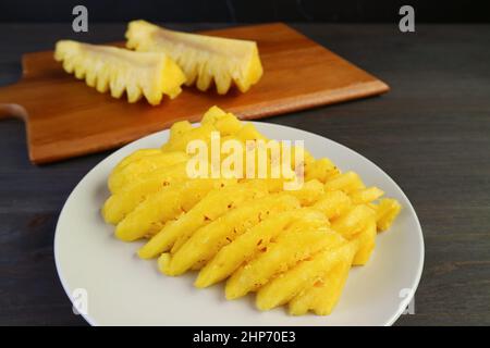 Nahauffangscheiben frischer, reifer Ananas auf einem weißen Teller, fertig zum Servieren Stockfoto