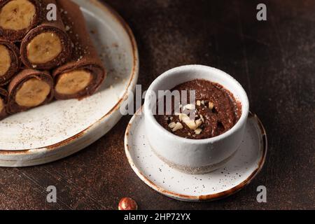 Vegane Schokolade Haselnuss in Keramikschale aufstreuen Stockfoto