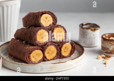 Gerollte vegane Schokoladencrepes mit Bananenfüllung Stockfoto