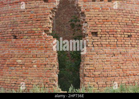 Brechen Sie in einer alten Backsteinmauer. Großer Riss im Wasserturm. Stockfoto