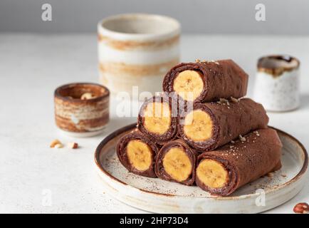 Vegane Schokoladen-Crepes mit Banane- und Schokoladenaufstrich-Füllung Stockfoto