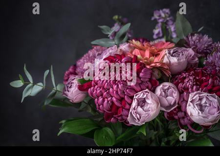 Blumenarrangement aus lila Chrysanthemen, Rosen und Eukalyptuszweigen Stockfoto