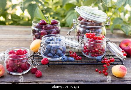 Verschiedene frische Sommerbeeren auf einem alten Holztisch Stockfoto