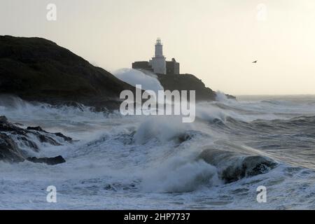 Sturm Eunice an den Mumbles. Swansea, Wales, Großbritannien. Die Wellen stürzen über Leuchtturm und Landzunge und 90mph Winde sprühen das Spray auf Stockfoto