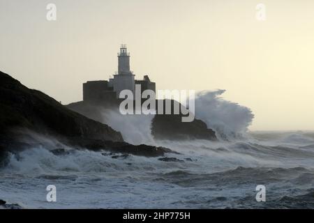 Sturm Eunice an den Mumbles. Swansea, Wales, Großbritannien. Riesige Wellen krachen über Leuchtturm und Landzunge, 90mph Winde wehen in den Wind. Stockfoto