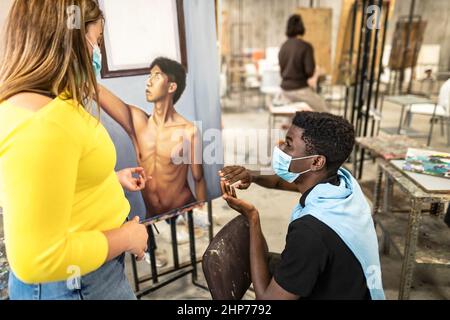 Junge Studenten tragen Gesichtsmaske während des Unterrichts in der Fakultät der Künste Universität - Lernen und Kultur Konzept Stockfoto