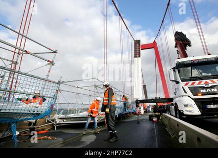 Emmerich, Deutschland. 19th. Februar 2022. Bauarbeiter bauen Gerüste auf der Emmerich-Rheinbrücke ab. Sturm Zeynep hatte Teile des Gerüsts auf die Straße geschoben. Der Verkehr über den Rhein ist bis auf weiteres gesperrt. Quelle: Roland Weihrauch/dpa/Alamy Live News Stockfoto