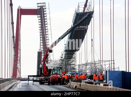 Emmerich, Deutschland. 19th. Februar 2022. Bauarbeiter bauen Gerüste auf der Emmerich-Rheinbrücke ab. Sturm Zeynep hatte Teile des Gerüsts auf die Straße geschoben. Der Verkehr über den Rhein ist bis auf weiteres gesperrt. Quelle: Roland Weihrauch/dpa/Alamy Live News Stockfoto