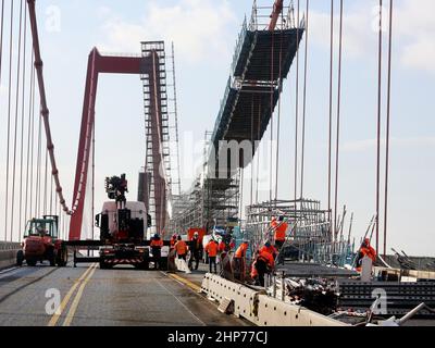 Emmerich, Deutschland. 19th. Februar 2022. Bauarbeiter bauen Gerüste auf der Emmerich-Rheinbrücke ab. Sturm Zeynep hatte Teile des Gerüsts auf die Straße geschoben. Der Verkehr über den Rhein ist bis auf weiteres gesperrt. Quelle: Roland Weihrauch/dpa/Alamy Live News Stockfoto