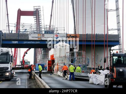 Emmerich, Deutschland. 19th. Februar 2022. Bauarbeiter bauen Gerüste auf der Emmerich-Rheinbrücke ab. Sturm Zeynep hatte Teile des Gerüsts auf die Straße geschoben. Der Verkehr über den Rhein ist bis auf weiteres gesperrt. Quelle: Roland Weihrauch/dpa/Alamy Live News Stockfoto