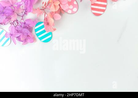 Bunte ostereier und Blumen. Bordüre mit rosa Frühlingsblumen. Frohe ostern Grüße Konzept, Urlaub Dekoration Hintergrund mit Kopie SPAC Stockfoto