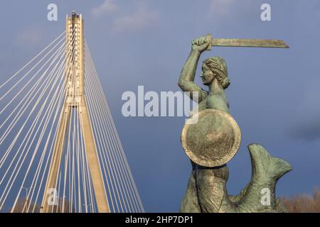 Statue der Meerjungfrau auf den Vistulan Boulevards und der Swietokrzyski Brücke über dem Ufer der Weichsel in Warschau Stockfoto