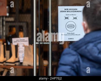 19. Februar 2022, Nordrhein-Westfalen, Dortmund: 'Wir heißen alle willkommen' und 2G und 3G durchgestrichene hängen im Fenster eines Schuhspeichers in der Innenstadt. Foto: Bernd Thissen/dpa Stockfoto