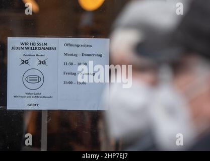 19. Februar 2022, Nordrhein-Westfalen, Dortmund: 'Wir heißen alle willkommen' und 2G und 3G durchgestrichene hängen im Fenster eines Schuhspeichers in der Innenstadt. Foto: Bernd Thissen/dpa Stockfoto