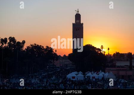 Marktplatz von Jemaa el-Fnaa bei Sonnenuntergang mit der Koutoubia Moschee in Marrakesch, Marokko.