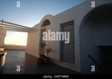 Santorini, Griechenland - 9. Mai 2021 : Blick auf eine wunderschöne weiße und grüne Villa mit einer großen Terrasse mit Blick auf die ägäis in Santorini Stockfoto