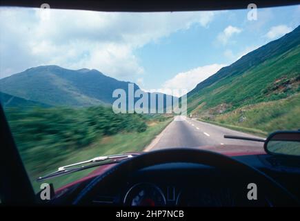 Blick durch die Windschutzscheibe auf einer Landstraße in Schottland, Stockfoto