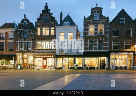 Nachtansicht zu Cafés und Geschäften am Markt, dem größten historischen Marktplatz in Europa, in Delft, Südholland, Niederlande Stockfoto