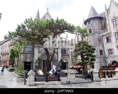 Da Nang, Vietnam - 12. April 2021: Touristen und Paare, die Hochzeitsfotos vor einer Kirche im französischen Dorf in Ba Na Hills machen, ein berühmtes Thema Stockfoto