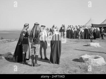 Geschichte des Nahen Ostens: Ein Stammesessen am Kavallerieposten in Tel-el-Meleiha, 20 Meilen nördlich von Beersheba, 18 1940. Januar. Gäste, die nach dem Essen im Gespräch stehen Ort: Israel ca. 1940 Stockfoto