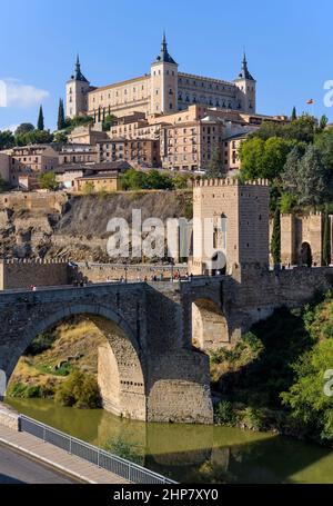 Toledo Spanien - Vertikale Morgenansicht der historischen Stadt Toledo bei Puente de Alcántara, mit Alcázar Festung hoch auf dem Hügel. Toledo, Spanien. Stockfoto