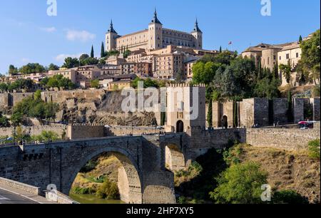 Toledo - Panoramablick auf die historische Stadt Toledo in der Puente de Alcántara, mit der Festung Alcázar, die hoch oben auf einem Hügel steht. Toledo, Spanien. Stockfoto