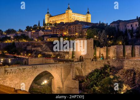 Toledo at Dusk - Panoramablick in der Dämmerung auf die historische Stadt Toledo in Puente de Alcántara, mit der Festung Alcázar, die hoch oben auf einem Hügel steht. Toledo, Spanien. Stockfoto