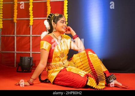 Junge Bharatnatyam-Tänzerin, die nach dem Tanzen auf der Bühne lacht - Konzept der Pause, Entspannung und professioneller Tänzer. Stockfoto