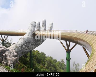 Da Nang, Vietnam - 12. April 2021: Goldene Brücke von riesigen Händen in Ba Na Hills, einem berühmten Themenpark und Resort in Zentralvietnam gehoben Stockfoto
