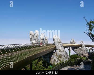 Da Nang, Vietnam - 12. April 2021: Goldene Brücke von riesigen Händen in Ba Na Hills, einem berühmten Themenpark und Resort in Zentralvietnam gehoben Stockfoto