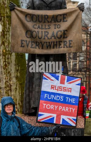 London, Großbritannien. 19th. Februar 2022. Ein Protestler, der behauptet, Russland würde vor Courage das Tory-Parteiion Londongrad finanzieren, ruft überall Mut auf, die Millicent Fawcett-Statue - vereint gegen Johnson-Protest auf dem Parliament Square. Organisiert vom Kollektiv Take Back Democracy, kommt der Protest nach Skandalen über Downing Street-Parteien und zweite Arbeitsplätze. Kredit: Guy Bell/Alamy Live Nachrichten Stockfoto