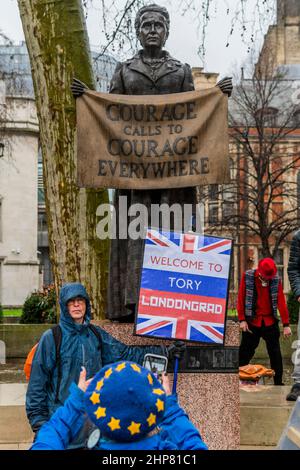 London, Großbritannien. 19th. Februar 2022. Ein Protestler, der behauptet, Russland würde vor Courage das Tory-Parteiion Londongrad finanzieren, ruft überall Mut auf, die Millicent Fawcett-Statue - vereint gegen Johnson-Protest auf dem Parliament Square. Organisiert vom Kollektiv Take Back Democracy, kommt der Protest nach Skandalen über Downing Street-Parteien und zweite Arbeitsplätze. Kredit: Guy Bell/Alamy Live Nachrichten Stockfoto