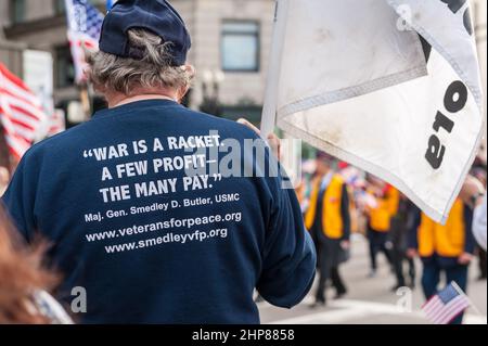 Mann mit dem Rücken zur Kamera und T-Shirt mit „war is a Racket“. Ein paar Gewinne - The Many Pay' bei der Boston Veterans Day Parade 2014 Stockfoto