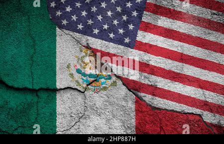 Vollformatfoto mit verwitterten Flaggen von Mexiko und den Vereinigten Staaten (USA, USA, Amerika), gemalt auf einer rissigen Wand. Stockfoto