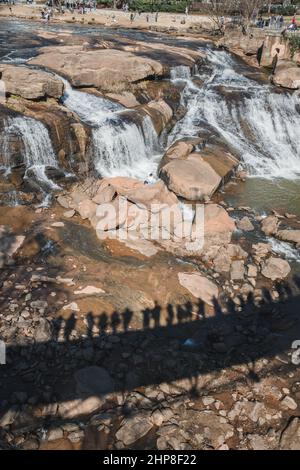 Falls Park on the Reedy ist ein toller Ort in der Innenstadt für ein Wochenende in Greenville, South Carolina mit Wanderwegen, Wasserfällen, Restaurants, Geschäften und Gärten. Stockfoto