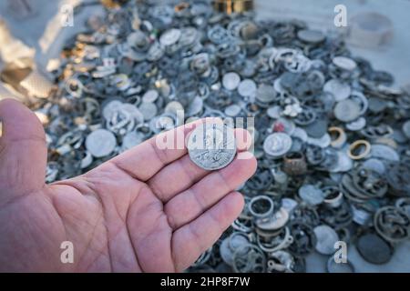 Alte römische Münze, in der Hand des Menschen, zeigt der Kamera, Hand berühren alte mittelalterliche Münzen. Stockfoto