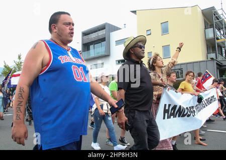 Christchurch, Neuseeland. 19th. Februar 2022. Anti-Mandats-Demonstranten marschieren mit einem Banner und Fahnen durch die Straßen von Christchurch. Tausende von Demonstranten haben das neuseeländische parlamentsgebäude Beehive aus Protest gegen das Covid-19-Anti-Impfstoff-Mandat umzingelt. Kredit: SOPA Images Limited/Alamy Live Nachrichten Stockfoto