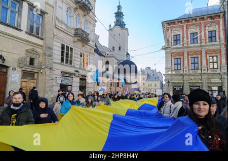 Lviv, Ukraine. 19th. Februar 2022. Die Ukrainer sahen während des Einheits-marsches an der Grenze zwischen Ukraine und Russland eine ukrainische Flagge halten.der Einheits-marsch begann in der Nähe des Denkmals von Ivan Franko und endete mit der Aufführung der Nationalhymne am Denkmal der Himmlischen Hundert Helden. Die Veranstaltung zeigte die Bereitschaft der Ukrainer, sich der russischen Aggression zu widersetzen. Kredit: SOPA Images Limited/Alamy Live Nachrichten Stockfoto