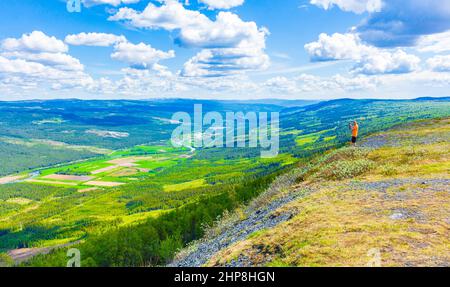 Tourist Reisende und Fotograf macht Bilder von einem schönen Tal Landschaft Panorama Norwegen von Hydalen Hemsedal mit Schnee in den Bergen in Summe Stockfoto