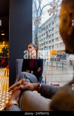 Zwei multirassische Geschäftspartner lachen und reden Stockfoto
