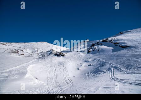 Schneebedeckte Berge der Sierra Nevada, Granada, Andalusien, Spanien mit dem Observatorium im Hintergrund an einem sonnigen Tag Stockfoto