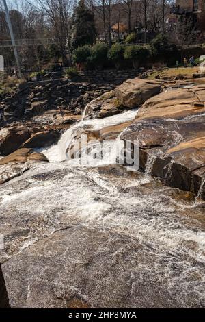 Falls Park on the Reedy ist ein toller Ort in der Innenstadt für ein Wochenende in Greenville, South Carolina mit Wanderwegen, Wasserfällen, Restaurants, Geschäften und Gärten. Stockfoto