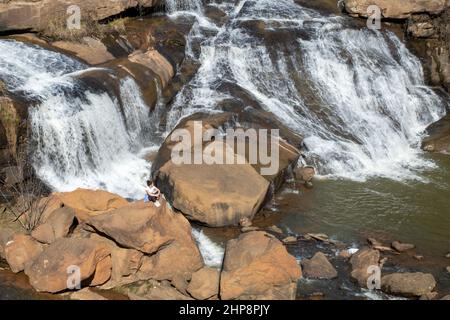 Falls Park on the Reedy ist ein toller Ort in der Innenstadt für ein Wochenende in Greenville, South Carolina mit Wanderwegen, Wasserfällen, Restaurants, Geschäften und Gärten. Stockfoto