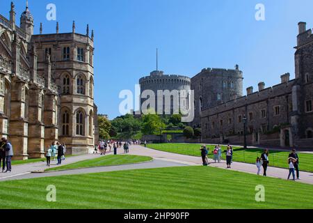 Besucher wandern auf den Pfaden neben der St. Georges Chapel im Unteren Bezirk von Windsor Castle, Großbritannien. Der runde Turm ist über dem Pfad zu sehen. Stockfoto